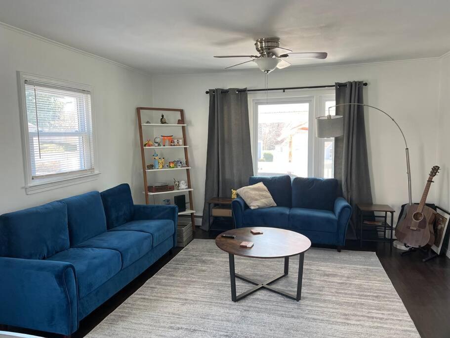 ein Wohnzimmer mit einem blauen Sofa und einem Tisch in der Unterkunft Quiet and Cozy Getaway in Milford in Milford