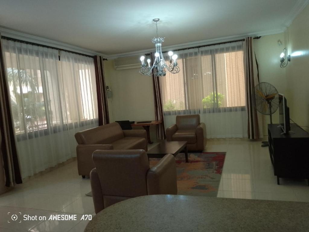 a living room with couches and a chandelier at Cozy 3BR w/pool & gym in Dar es Salaam