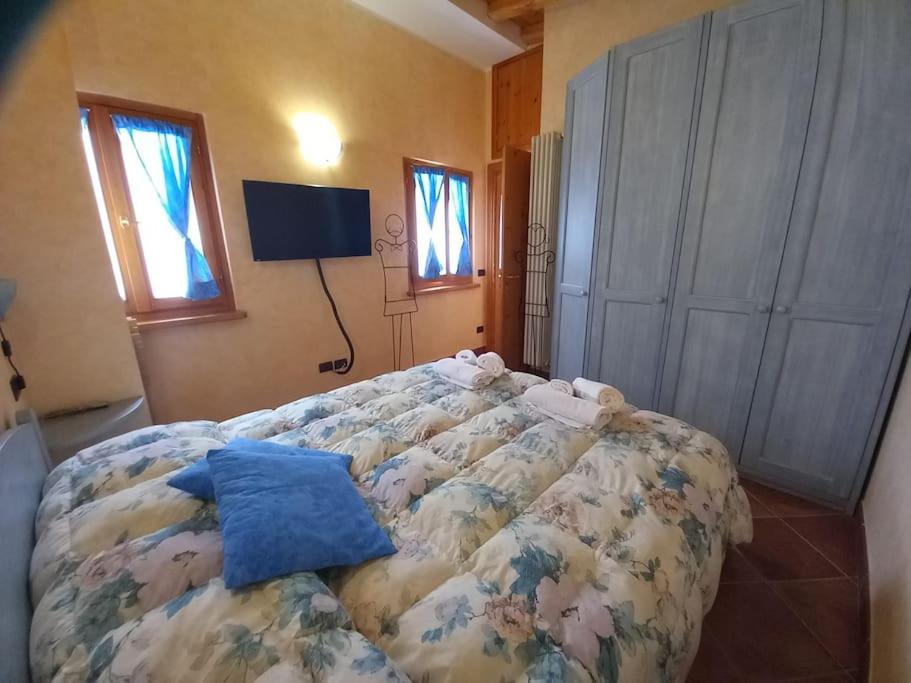 sypialnia z dużym łóżkiem w pokoju z oknami w obiekcie Casa Barbara w mieście Limone Piemonte