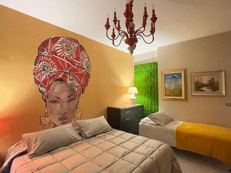 a bedroom with a painting of a woman on the wall at Appartamento Borgosesia Cuore Matto in Borgosesia