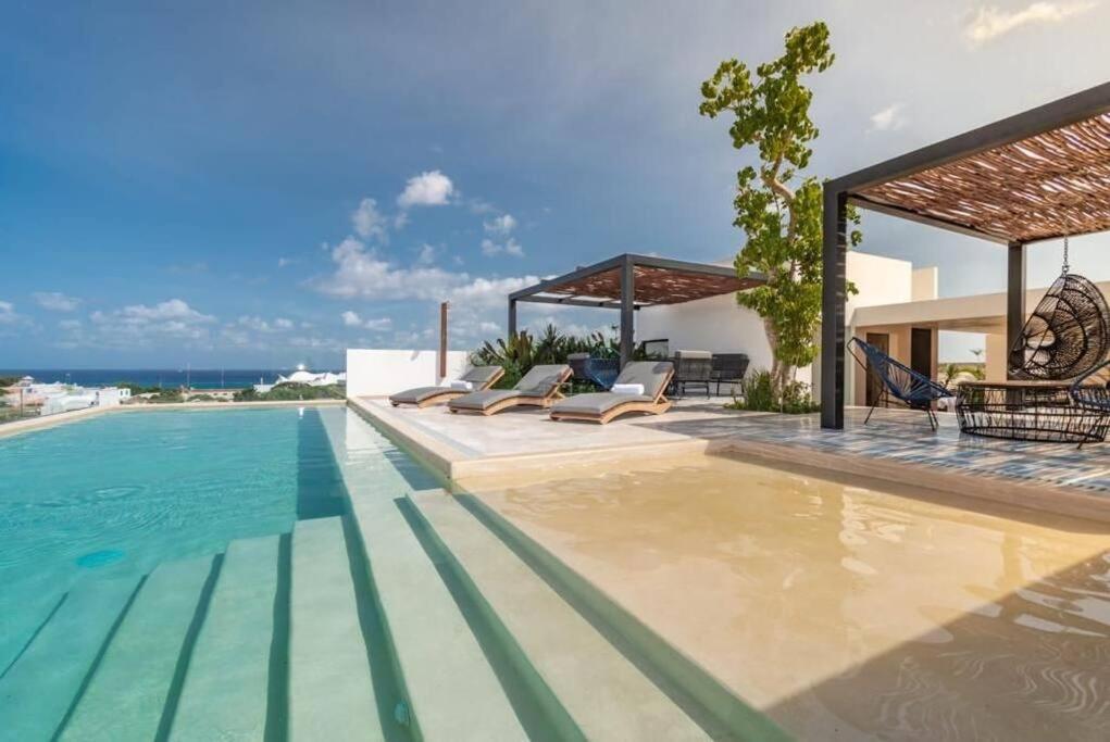 a villa with a swimming pool and a house at Nuevo y lujoso estudio céntrico in Playa del Carmen