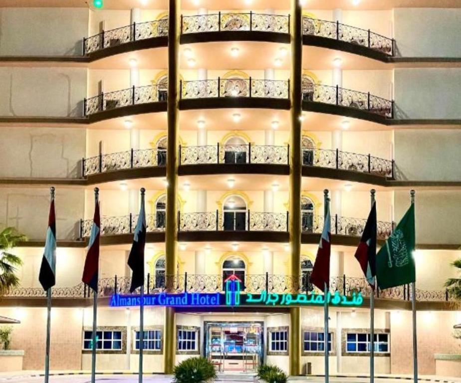 a large building with flags in front of it at Al Mansour Grand Hotel in Hafr Al-Batin