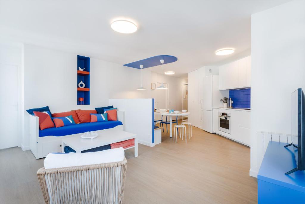ein Wohnzimmer mit einem blauen Sofa und einem Tisch in der Unterkunft La Serrisienne 7 - Val d'Europe - Disneyland Paris - 6 à 8 Personnes in Serris