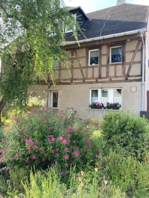 Ein Haus mit einem Haufen Blumen davor in der Unterkunft Wohnen im Grünen bei der Töpferei in Erfurt