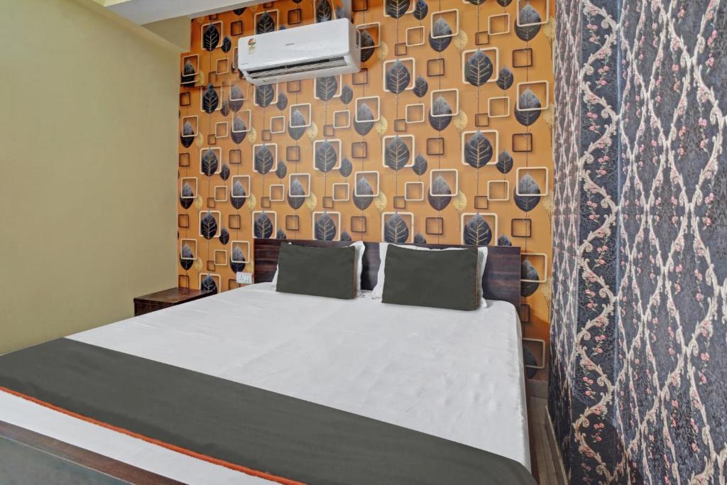 1 dormitorio con 1 cama y una pared con en OYO Flagship Welcome 24x7 en Patna
