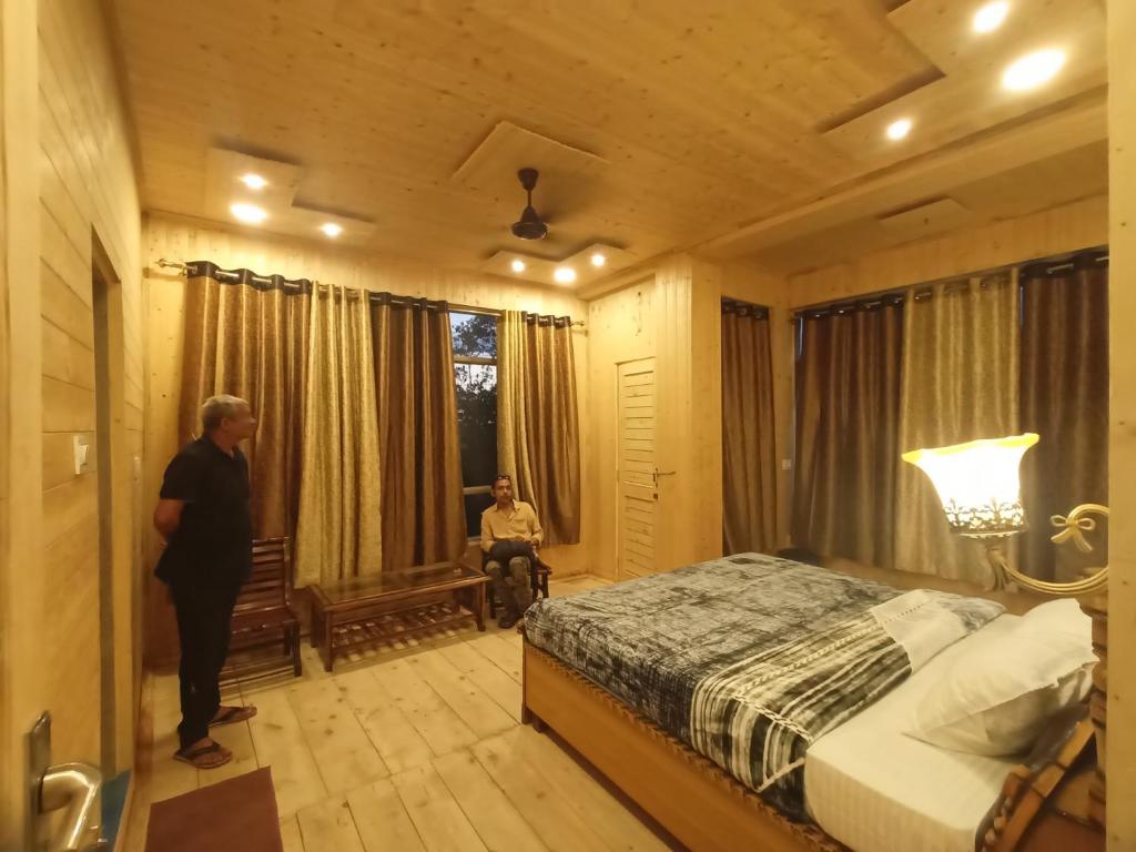 een man in een slaapkamer met een bed bij RIGVEDA Bir Billing in Bir