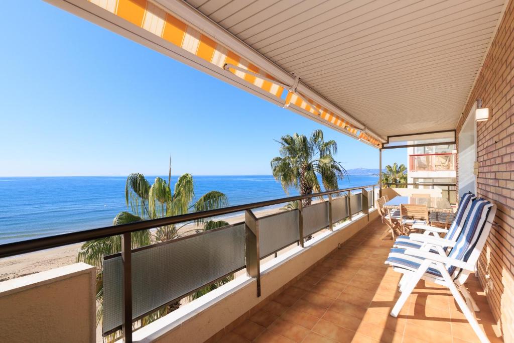 a balcony with chairs and a view of the ocean at Apartamento para 8 sobre el mar in Salou
