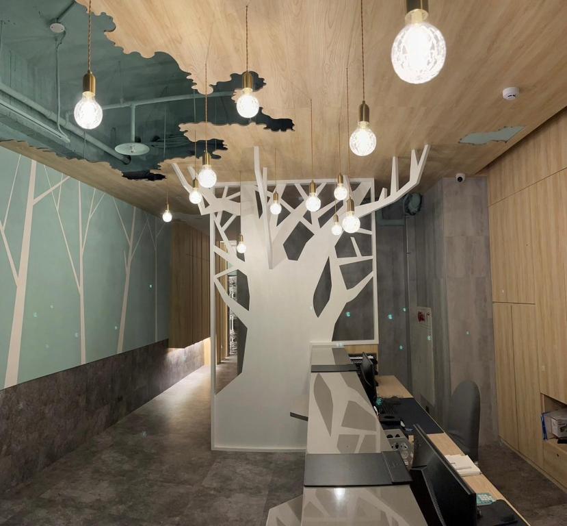 a lobby with a large tree sculpture on the wall at 新仕飯店-New City Hotel in Taipei