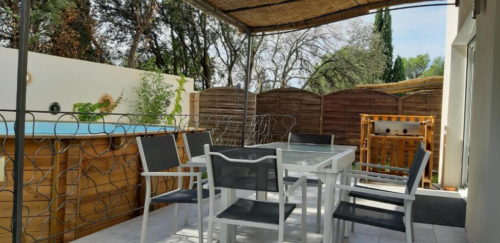 un patio avec une table et des chaises et une clôture dans l'établissement La maison des Cigales, à Montferrier-sur-Lez