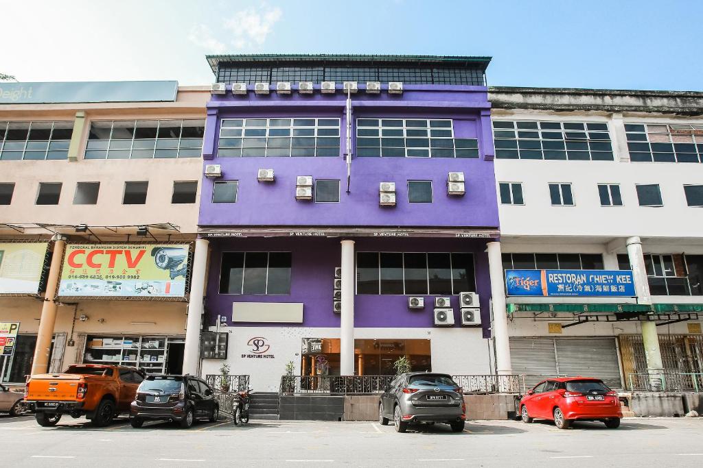 een paars gebouw met auto's ervoor geparkeerd bij SP Venture Boutique Hotel in Rawang