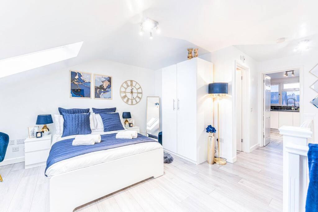 a white bedroom with blue and white furniture at Luxury Apartment - Close to City Centre - Free Parking, Fast Wifi and SmartTV by Yoko Property in Coventry