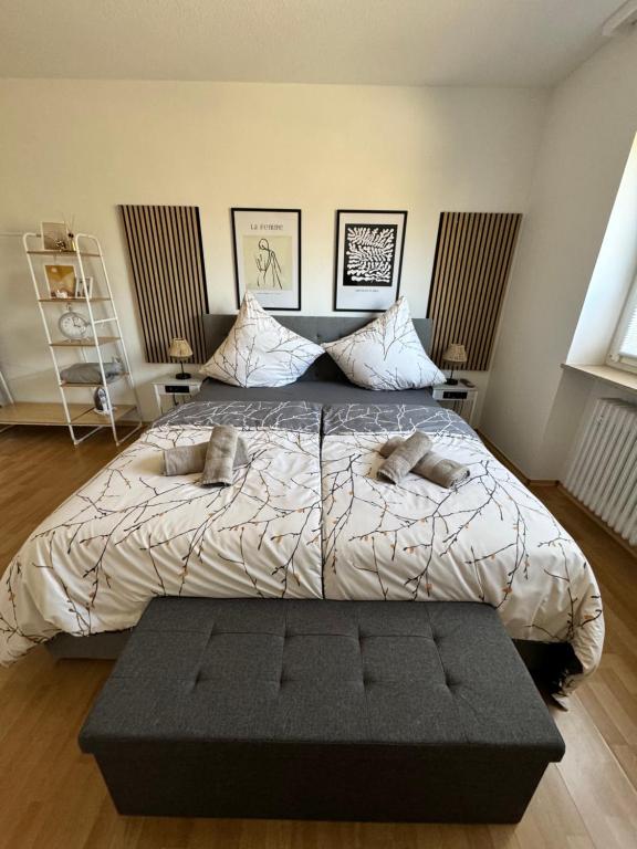 a bedroom with a large bed with a black ottoman at Feel like Home 3 in Biberach an der Riß