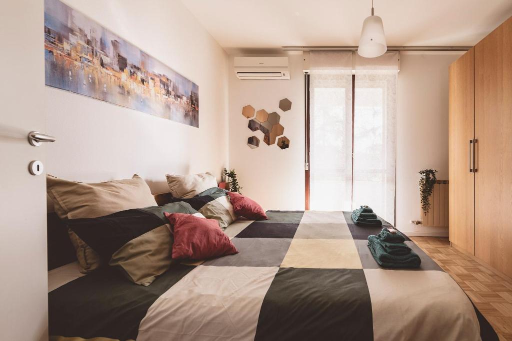 ein Schlafzimmer mit einem großen Bett mit Kissen darauf in der Unterkunft Casa Zoe 2 Apartment(Parking,Self Check-in & Wi-Fi) in Parma