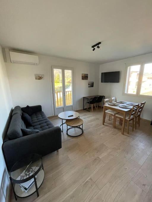a living room with a couch and a table at Maison mitoyenne 60m2 en campagne in Montailleur
