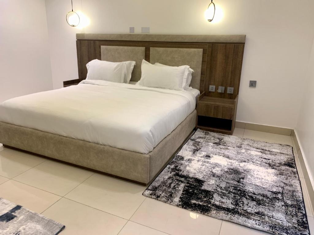 Polo Grand Hotel في Maiduguri: غرفة نوم بسرير كبير وسجادة