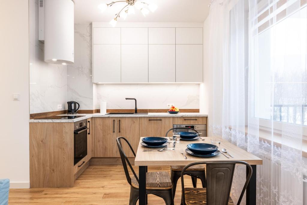 a kitchen with a table with chairs and a sink at Lis i Ryś in Ustrzyki Dolne