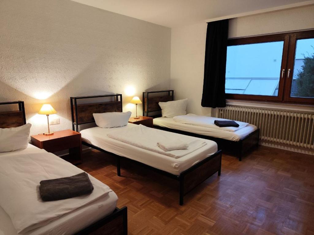 una camera con tre letti e una finestra di Großes Haus für Monteure a Sandweier