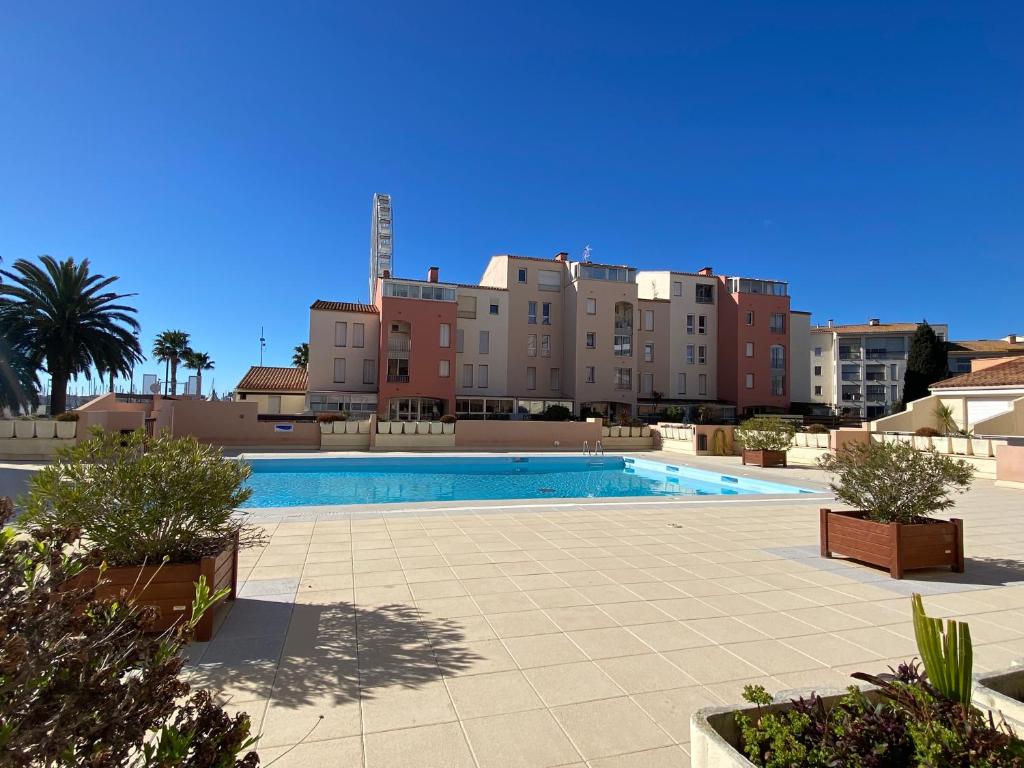 una gran piscina con edificios en el fondo en Studio Centre Port avec piscine résidence Port Richelieu en Cap d'Agde
