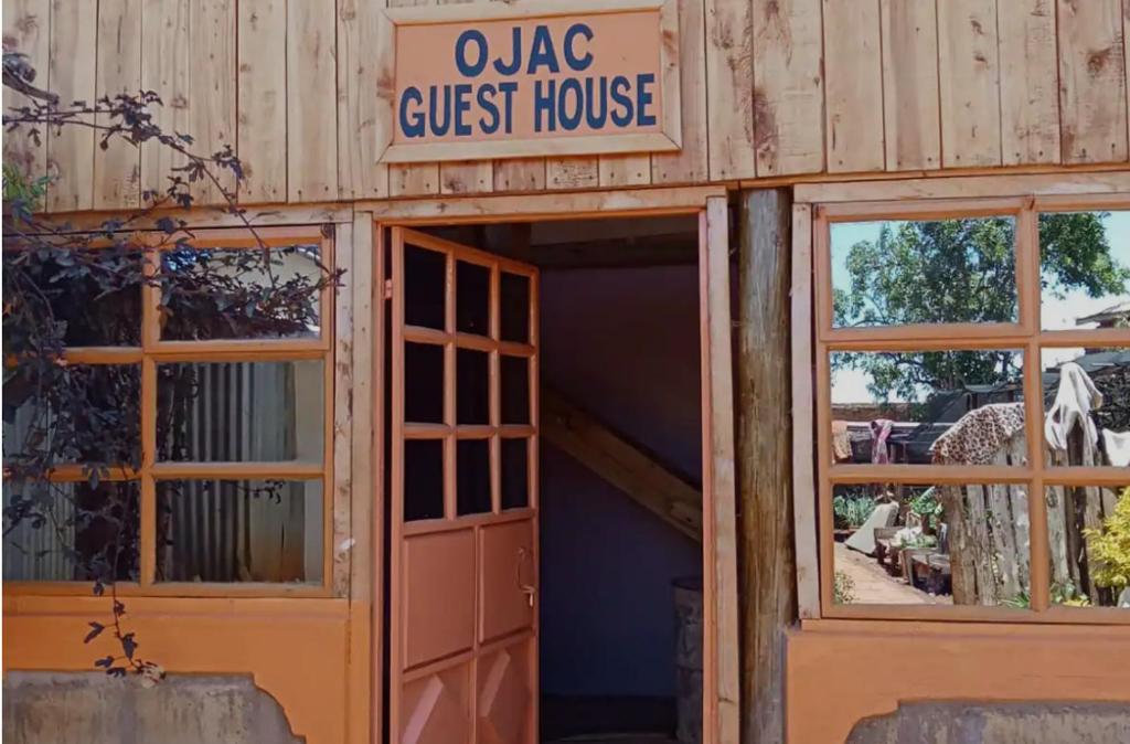eine Tür zu einer Pension mit einem Schild darüber in der Unterkunft Ojac Guest House - Iten in Iten