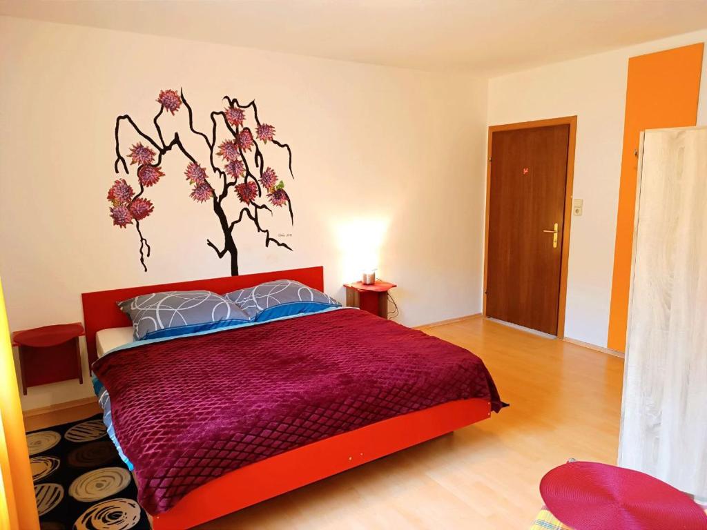 a bedroom with a bed with a flower mural on the wall at Hotel Zemlinski in Payerbach
