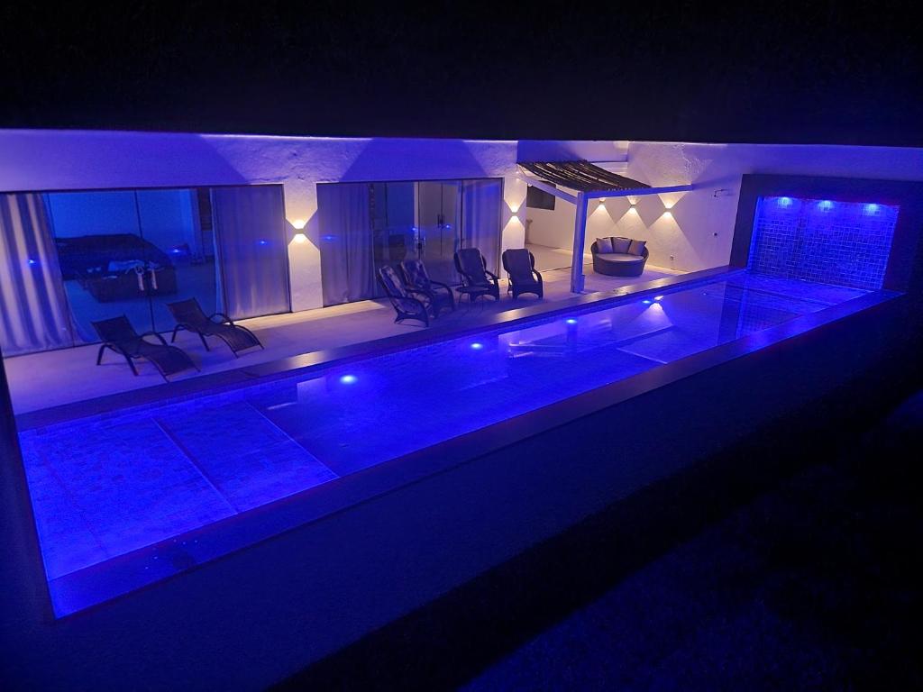 ein Pool in einem Haus mit blauen Lichtern in der Unterkunft Fazenda de Jehne - Casa completa in Camamu