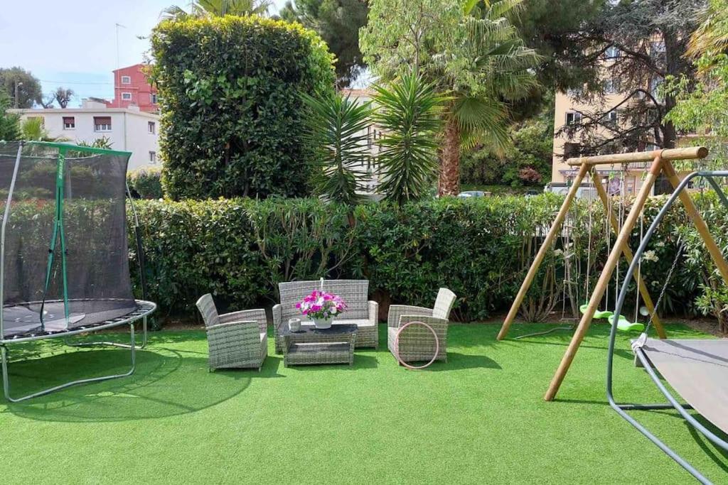 une aire de jeux avec des chaises et une balançoire dans l'établissement Très belle appartement, à Cagnes-sur-Mer