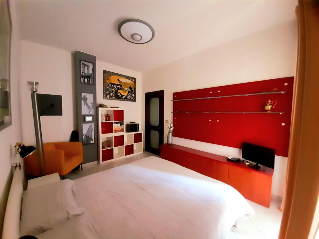 a bedroom with a large bed and a red wall at La Ludocanda in Turin