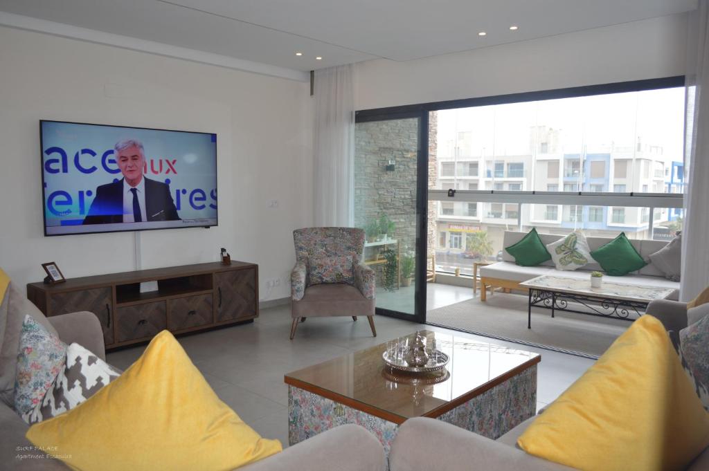 a living room with a tv on a wall at SURF PALACE BEACHFRONT APARTMENT Essaouira in Essaouira
