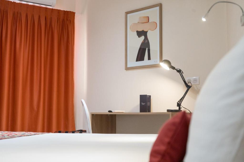 Hôtel AL AFIFA في داكار: غرفة نوم مع سرير ومكتب مع مصباح