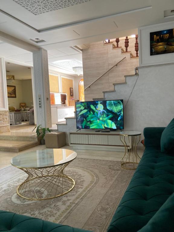 salon z kanapą i telewizorem w obiekcie Villa bella w mieście Kenitra