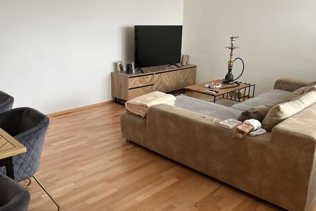 ein Wohnzimmer mit einem Sofa und einem Flachbild-TV in der Unterkunft Wels Bahnhoft Stadt 80qm Apartment in Wels