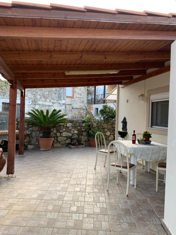 eine Terrasse mit einem Tisch und Stühlen unter einer hölzernen Pergola in der Unterkunft Manousos Guest House in Iraklio