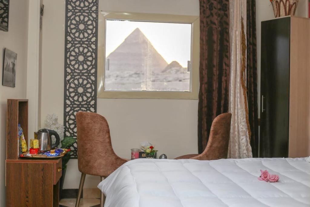 een slaapkamer met een bed en uitzicht op de piramides bij pyramids light show in Caïro
