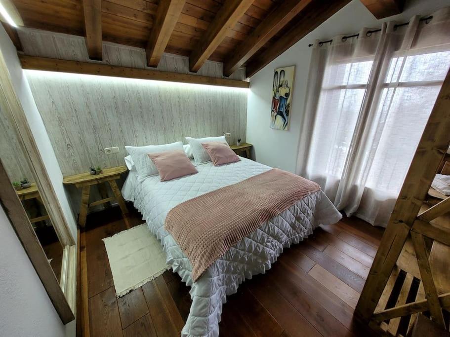 ein Schlafzimmer mit einem großen Bett und einem Fenster in der Unterkunft El Pajar de la Plaza in Guaso