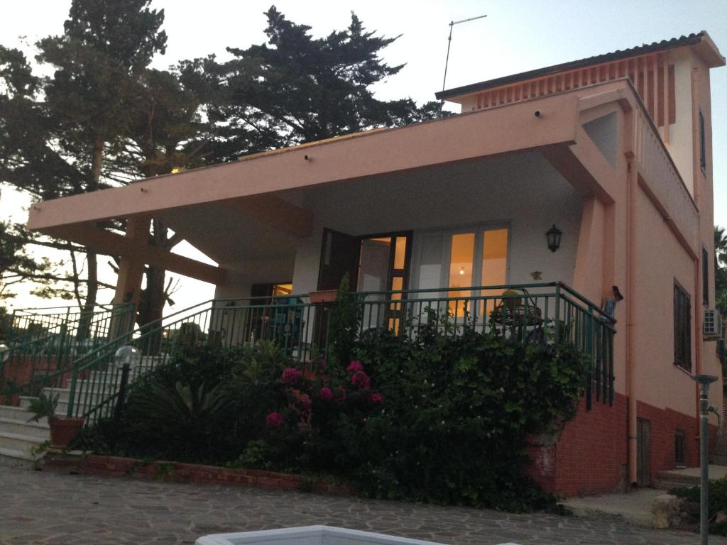 een klein roze huis met een balkon bij Casa Vacanze Palma in Realmonte