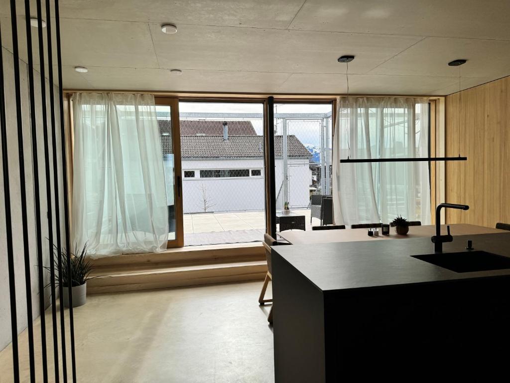 eine Küche mit einem großen Fenster und einer Kücheninsel in der Unterkunft Architektenhaus RHaa mit Terrassen in Altach