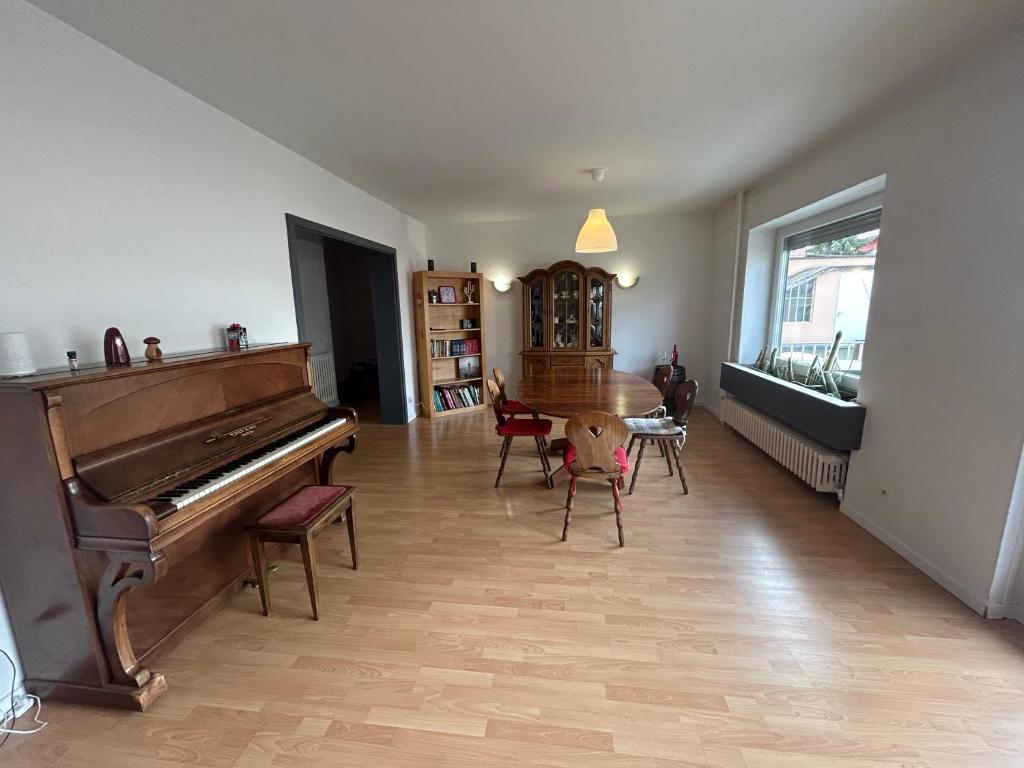 sala de estar con piano, mesa y sillas en Superbe appartement avec belle terrasse, en Bischheim