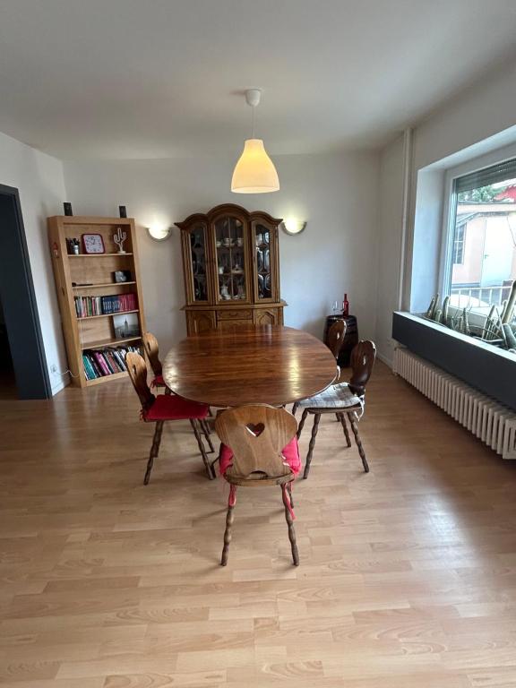 a dining room with a wooden table and chairs at "Spacious Family Apartment & Parking near Strasbourg Center with easy bus Access" in Bischheim