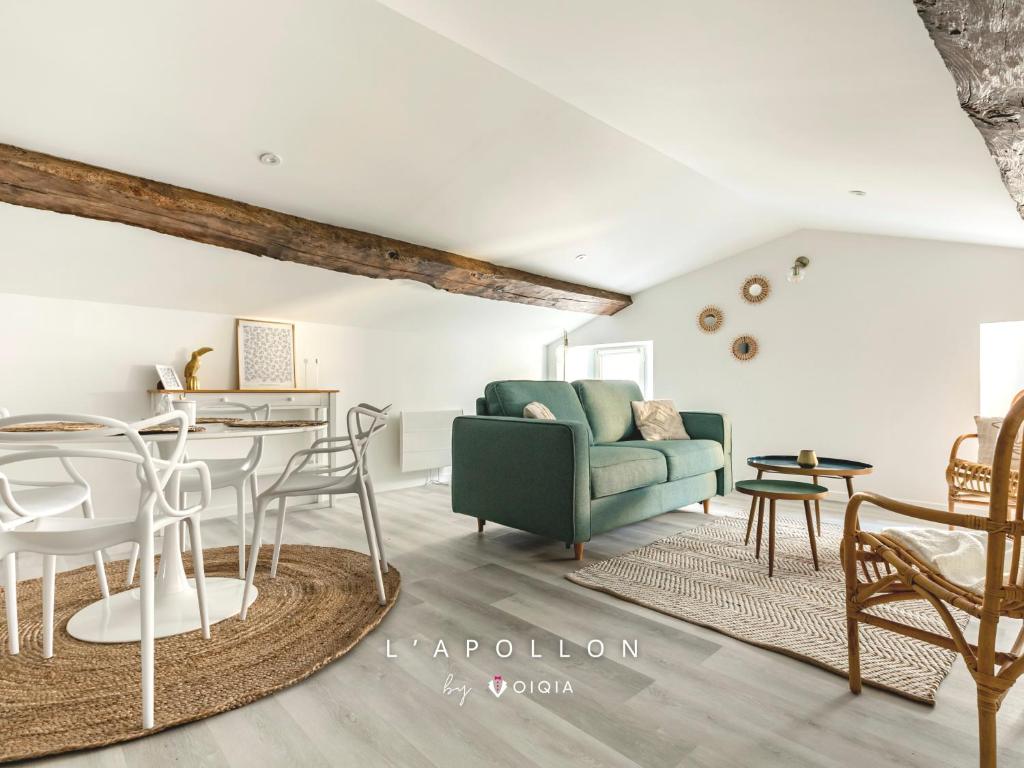 een woonkamer met een groene bank en een tafel bij L'Apollon - Centre-Ville - Climatisation - Arrivée Autonome in Niort