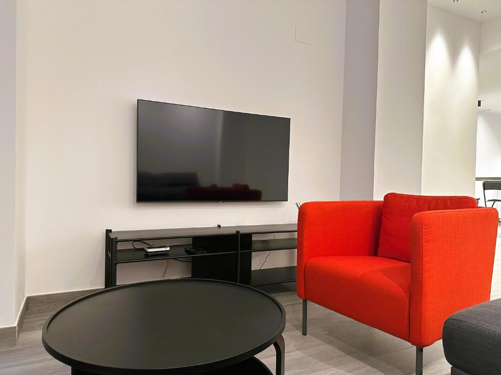 a living room with a red chair and a tv at Esteve Silence in Valencia