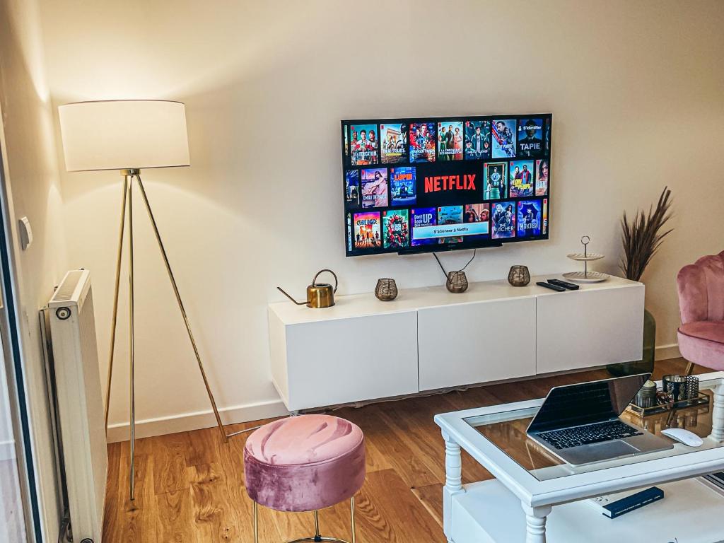 サント・ジュヌヴィエーヴ・デ・ボワにあるCosy Haven SGDBの壁にテレビが取り付けられたリビングルーム