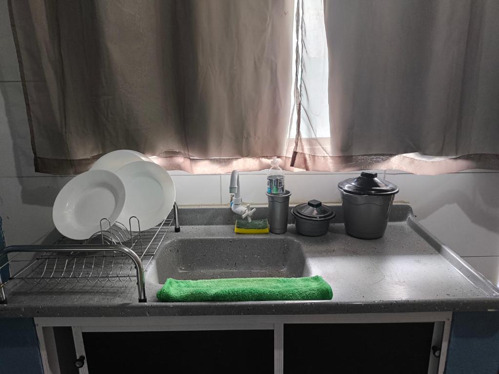 a kitchen sink with a plate and aainer at Kitnet Aconchegante in Foz do Iguaçu