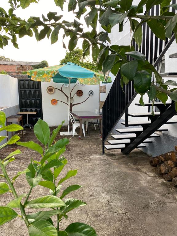 een patio met een blauwe parasol en een tafel bij La casa de Alejandra, planta alta. in Perales del Puerto
