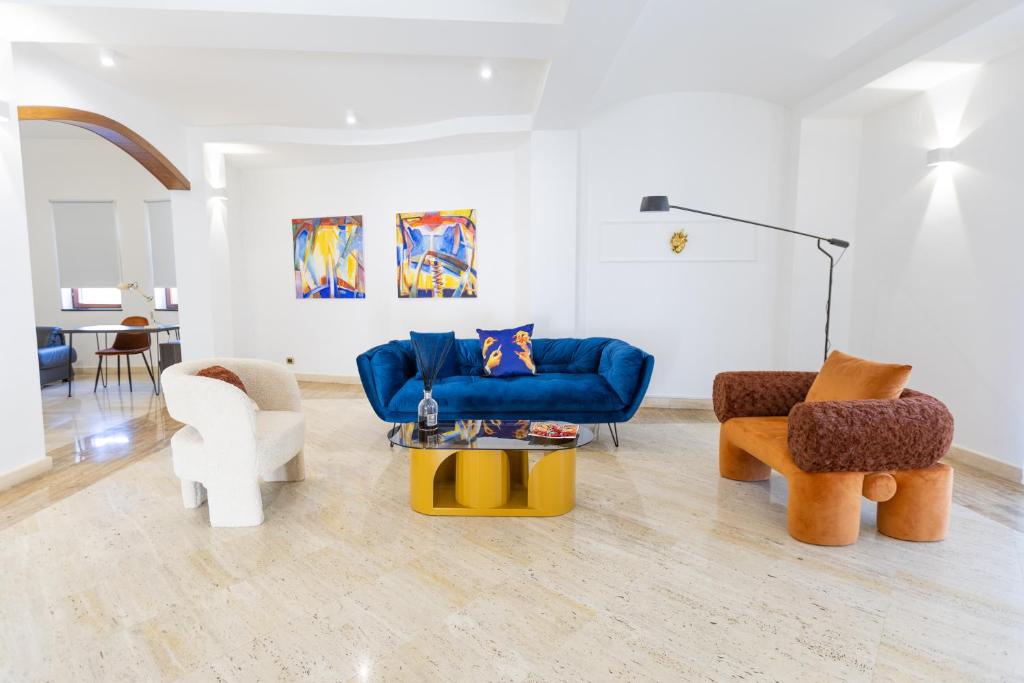 uma sala de estar com um sofá azul e cadeiras em Villa Vetrano em Cimitile
