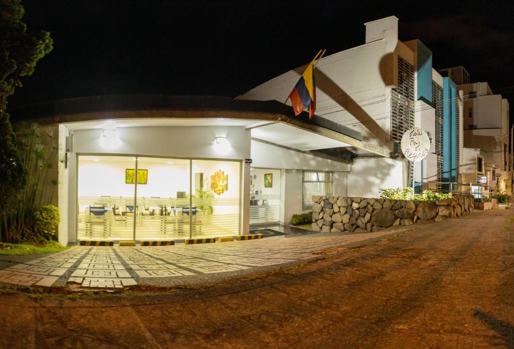 a building with a restaurant on a street at night at Hotel Regine's Manizales in Manizales