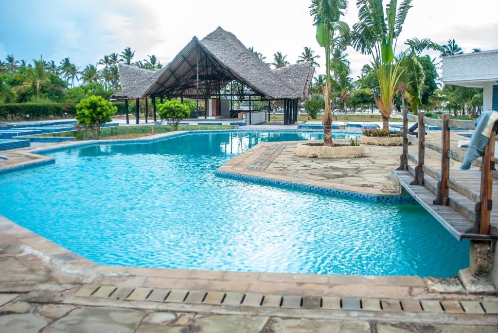 einen Pool in einem Resort mit blauem Wasser in der Unterkunft Harmony Homes Beachfront in Diani Beach
