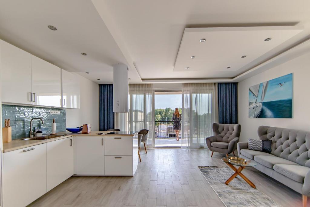 een keuken en een woonkamer met een bank en een tafel bij Opal Apartments in Balatonkenese