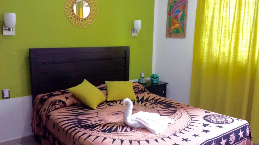 a bedroom with a swan laying on a bed at Maya Vacanze Playa Quinta B&B in Playa del Carmen