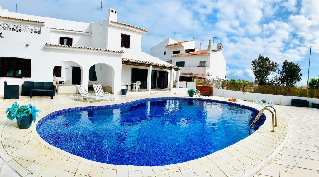 a swimming pool in front of a house at VILLAMOR in Albufeira