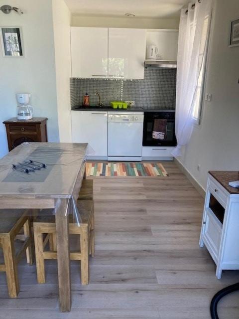 Il comprend une cuisine avec une table et du parquet. dans l'établissement Mini villa villa Gallargues le Montueux jardinet / piscine partagée, à Gallargues-le-Montueux